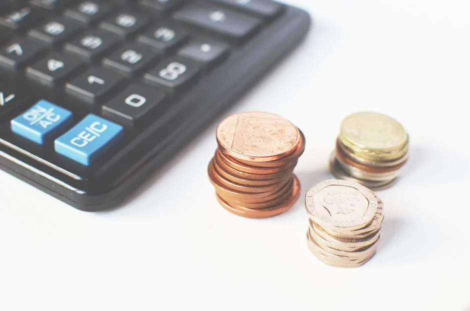 Stacked coins beside a calculator, illustrating the financial planning behind GTM engineer salaries and career growth in