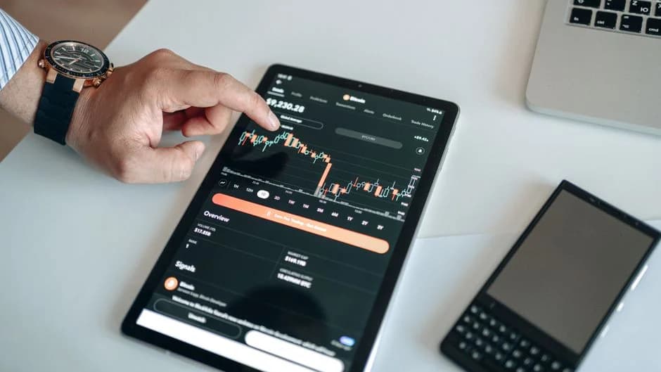 Person analyzing a cryptocurrency market chart on a tablet, reviewing data and cost insights for a RevOps AI agents plat