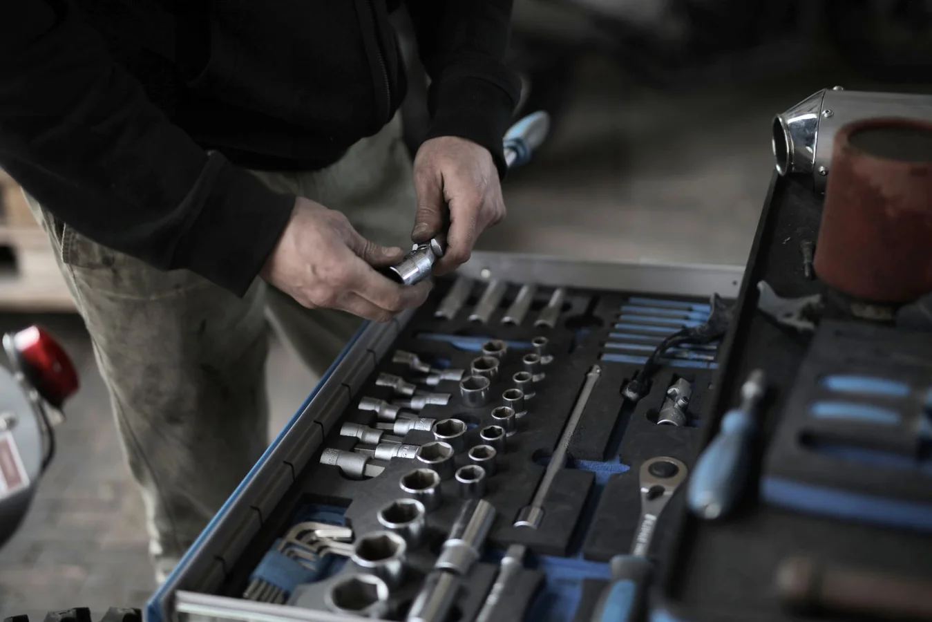 Hands selecting tools from an organized toolset