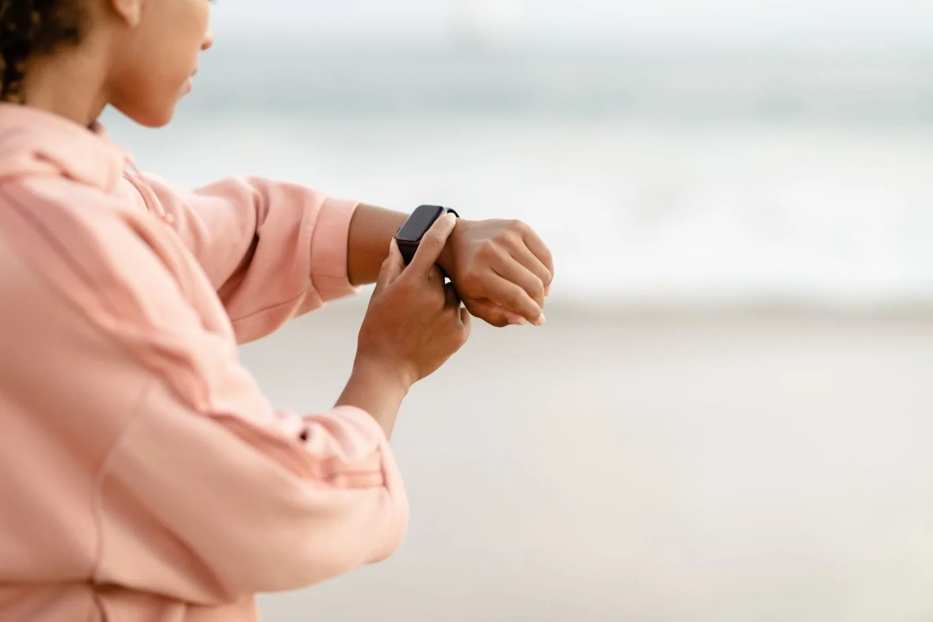 Person checking a smartwatch on their wrist outdoors