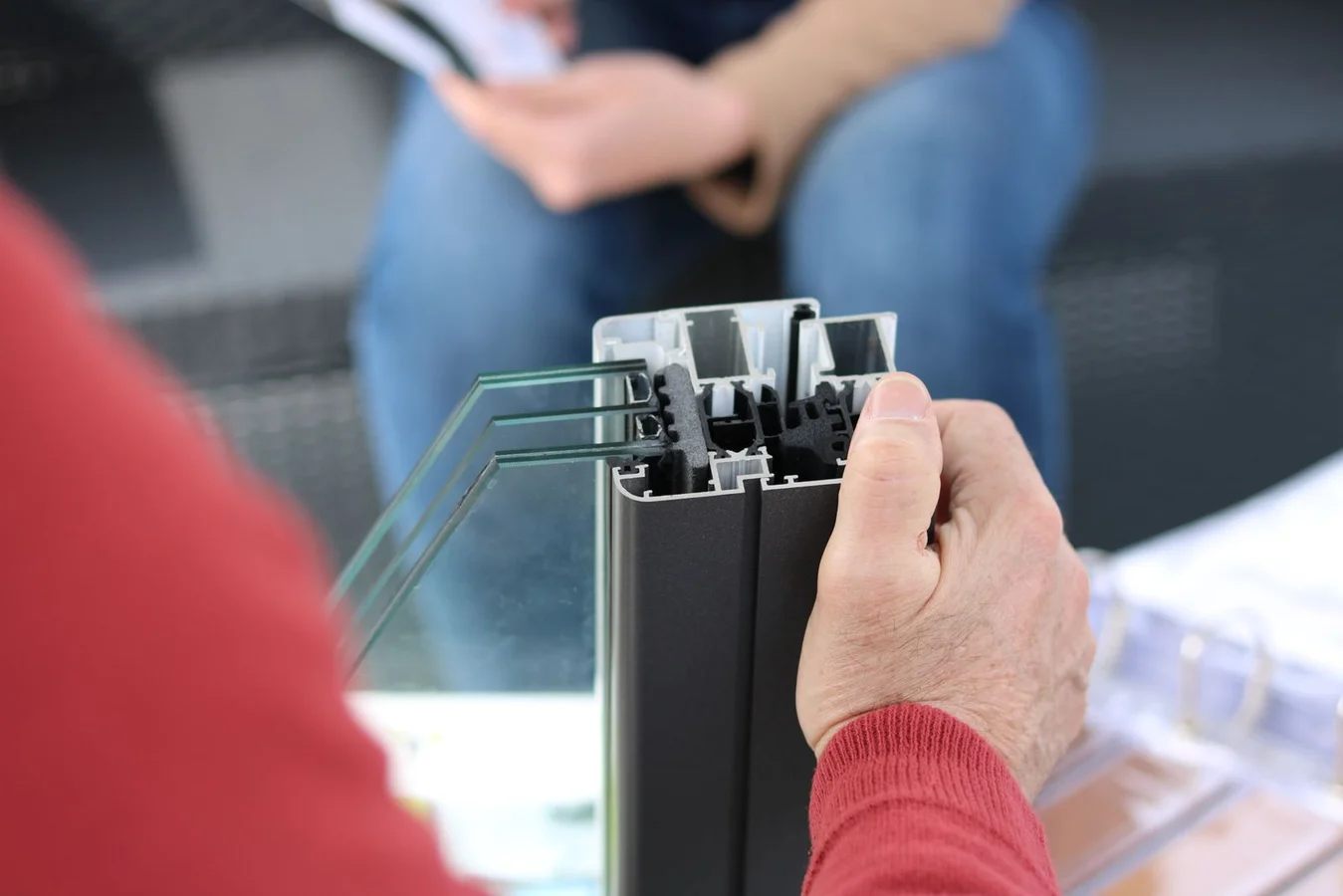 Hands holding an aluminium window frame sample